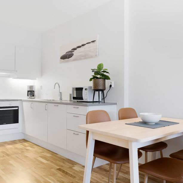 Moderne og lyst kjøkken med spisebord og spisestoler